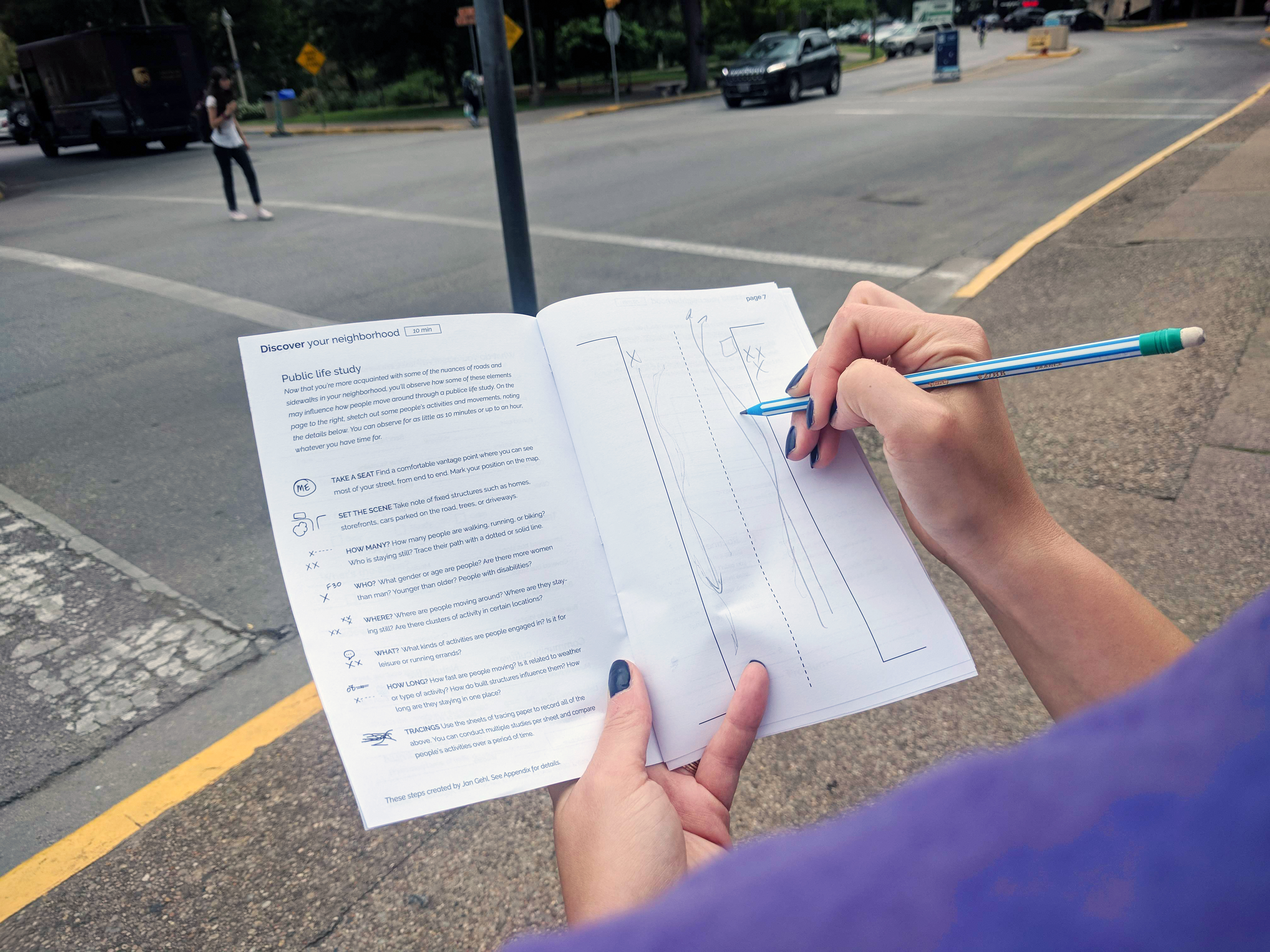 Person using ChalkTalk booklet to observe city streets.